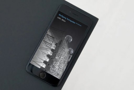 Handy, an der Tischkante liegend, mit der Startseite von Wolfgang Tschapeller Architekten