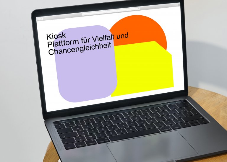 Ein aufgeklappter Laptop auf einem Stuhl mit der Startseite von Kiosk – Plattform Vielfalt