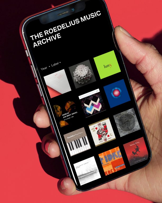 Hand hält Handy mit Webseite "The Roedelius Music Archive"