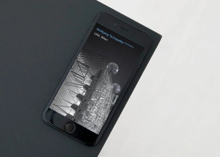 Handy, an der Tischkante liegend, mit der Startseite von Wolfgang Tschapeller Architekten