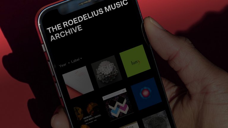 Hand hält Handy mit Webseite "The Roedelius Music Archive"